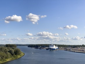 Scandinavienkai Tavemünde with large Finnlines ferry in port, surrounded by water and fluffy