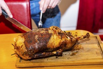 Grilled Christmas goose is expertly carved. Münsingen, Baden-Württemberg, Germany