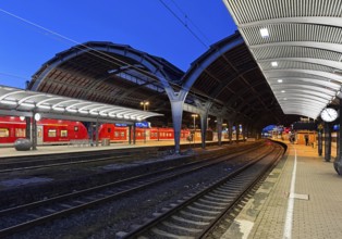 Empty platform with the two-nave platform hall and regional express in the evening, central railway