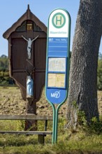 MVV bus stop at a traditional field cross, wayside cross, bench and oak (Quercus) in a field,