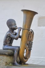 Sculpture boy with tuba by Guido Messer 1991, modern art, bronze sculpture, playing music, tuba,