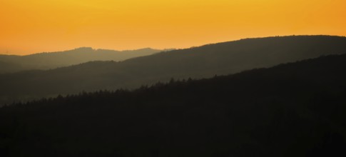 Silhouettes of mountains at sunset with orange sky, Vadsö, Finnmark, Norway