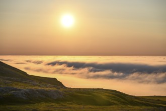 View from Mount Domen. Dense sea fog hangs over the Barents Sea the midnight sun shines in the