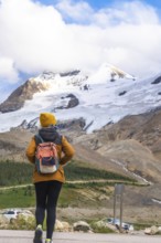 Female hiker walking towards the athabasca glacier in the columbia icefield, jasper national park