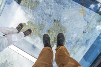 Tourists are enjoying the breathtaking view from the glass floored skywalk. Overlooking the