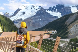 Tourist admiring breathtaking views of the canadian rockies from the glacier skywalk, a glass
