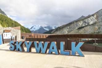 Welcoming sign marking the glass floored skywalk over sunwapta valley, with the athabasca glacier