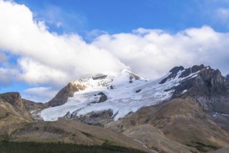 Athabasca glacier is melting under a cloudy sky, showing the effects of climate change on the