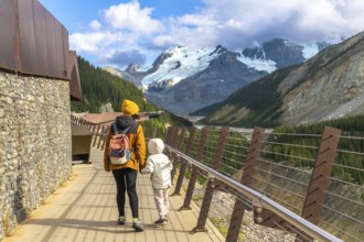 Mother and child walking on the glacier skywalk, enjoying the breathtaking view of the athabasca