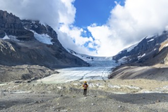 Hiker standing in front of the impressive athabasca glacier in jasper national park, canadian