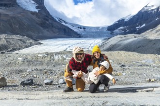 Happy family is having fun while visiting the athabasca glacier in the canadian rockies, jasper