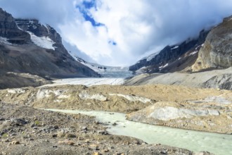 Turquoise meltwater flows from athabasca glacier in jasper national park, showcasing the effects of