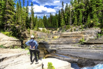 Two tourists admiring the stunning view of mistaya canyon in banff national park, featuring unique