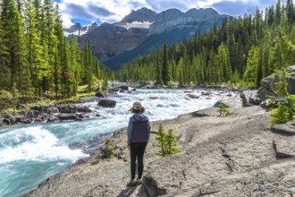 Female hiker admiring the turquoise waters of mistaya river flowing through mistaya canyon in banff