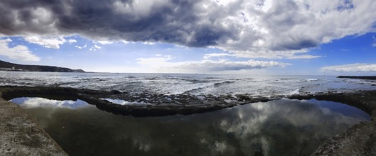 Broad view of a coastal landscape with cloud reflection in the water, Los Cristianos, Tenerife