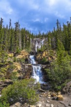 Water cascading over rocky cliffs at tangle creek falls in jasper national park showcases nature's