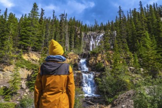 Female hiker in a yellow beanie and jacket enjoying breathtaking views of tangle creek falls
