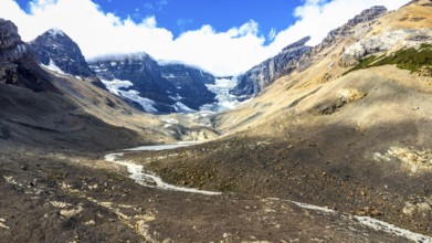 Melting athabasca glacier reveals rocky terrain beneath, creating a striking brown and white