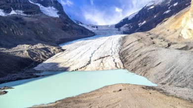 Athabasca glacier flows into a vibrant turquoise lake, showcasing the effects of climate change on