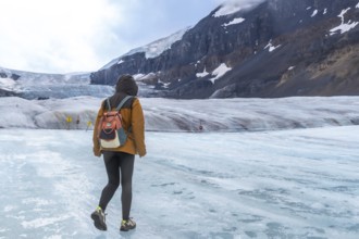 Tourist walking on the surface of athabasca glacier in jasper national park in the canadian rockies