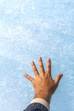 Tourist in a jacket touching the ancient ice of athabasca glacier in jasper national park,