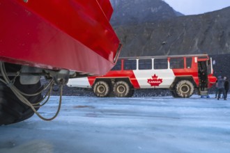Red ice explorer buses standing on the athabasca glacier in the columbia icefield area of jasper