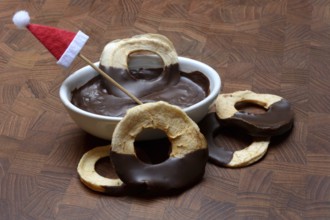 Apple rings, coated with chocolate, chocolate glaze in bowl