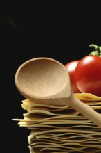 Cooking spoon and lasagna leaves with tomatoes