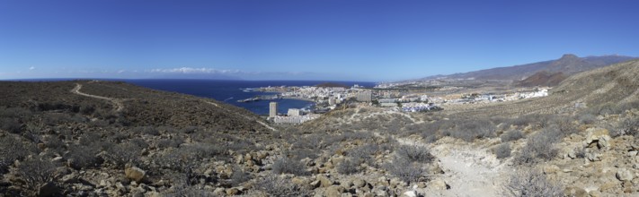 Panoramic view of the tourist town of Los Cristianos with the sea in the foreground and mountains