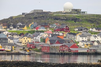 City view of Vardö with NATO radar dome, colorful coastal town with houses on the water, overlooked
