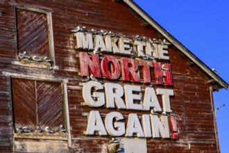Red fishing building with the inscription Make the North great again at Vardö harbour, Vardø,