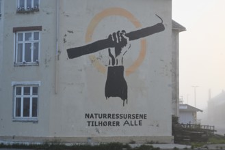 Wall painting with stretched arm and gaff. The inscription says Natural resources belong to