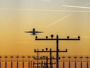 Runway lighting, approach aids, at Düsseldorf International Airport, sunset, aircraft taking off,