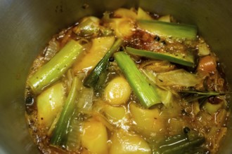 A vegetable stock is cooked, various vegetables are boiled with spices and herbs in water for a