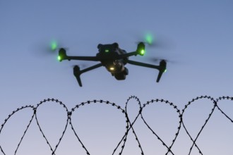 Symbolic picture, drone with glowing propellers over waves of barbed wire, airport, threat,