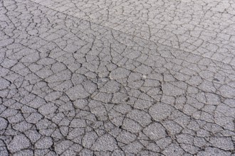 Asphalt surface, floor, with many small cracks, roadway, parking lot