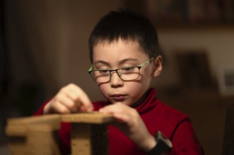 Boy, 6 years, glasses, multi-ethnic, plays concentrated, constructs, builds, Stuttgart,