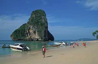 Rocks in the sea, boats and people on Pranang Cave beach, two years in front of the tsunami, Krabi,