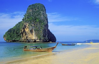 Rocks in the sea and longtail boats on Pranang Cave beach, two years in front of the tsunami,