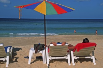 People holding umbrellas and sun loungers on Karon Beach, two years in front of the tsunami, Ko