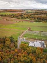 Aerial view of an autumn landscape with colorful trees and fields under cloudy sky, Energiewende,