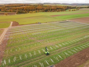 Wide fields with solar panels and green landscape in the background, energy revolution,