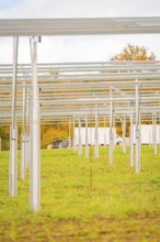 Metal structures for a solar system on a field covered with grass in autumn, energy revolution,