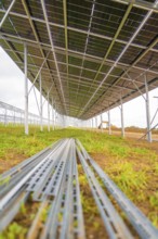 Ground view under a metal structure being built for solar modules, Energiewende, construction of PV