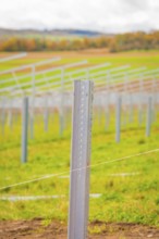Close-up of a metal rod that is part of a larger field installation, with blurred landscape in the