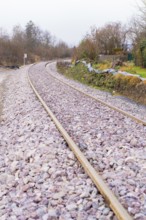 Close-up of a winding railway line with rails and gravel, construction of the Hermann Hesse