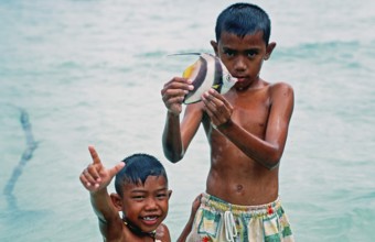 Two boys with a tropical fish on Ko Phi Phi Don, two years in front of the tsunami, Thailand,