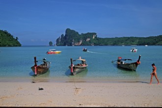 Young woman, longtail boats on the beach of Ko Phi Phi Don, two years in front of the tsunami,