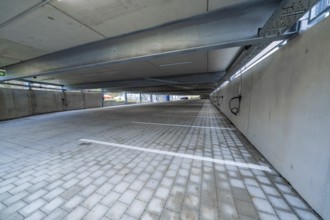 Empty covered parking lot with concrete structure and marked parking spaces, parking garage