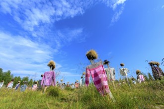 Artwork outdoor installation The silent people of Reijo Kela Straw dolls wear colorful clothes in a